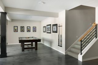 gaming room with pool table, pool cues on wall, pictures, grey flooring, cream walls