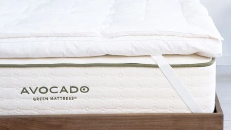 Avocado mattress topper on a white Avocado mattress and a dark wood bedframe