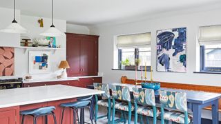 Red cabinets and kitchen island, blue dining table and chairs