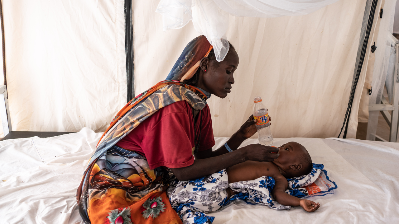 Nadifa Mohamed Adam, 22, gives water to his child who is suffering from fever and malnutrition at the malaria department tent in the Doctors Without Borders clinic inside the Adre camp, where around 200,000 people are currently taking refuge on September 19, 2023 in Adre, Chad. The conflict in Sudan, entering its sixth month, has left thousands of civilians dead and displaced more than five million people. More than 420,000 people have already found refuge in neighbouring Chad as hundreds continue to arrive daily. 