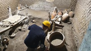 Archaeologists inside the 'slave room' recently unearthed in a Pompeii villa.