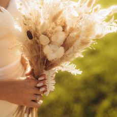 A bride holding a bouquet of dried flowers