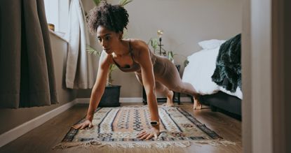 Fitness, black woman and push up exercise in home for wellness, healthy lifestyle and workout. Young sports person, plank and female athlete on bedroom floor with strong core, body muscle and power