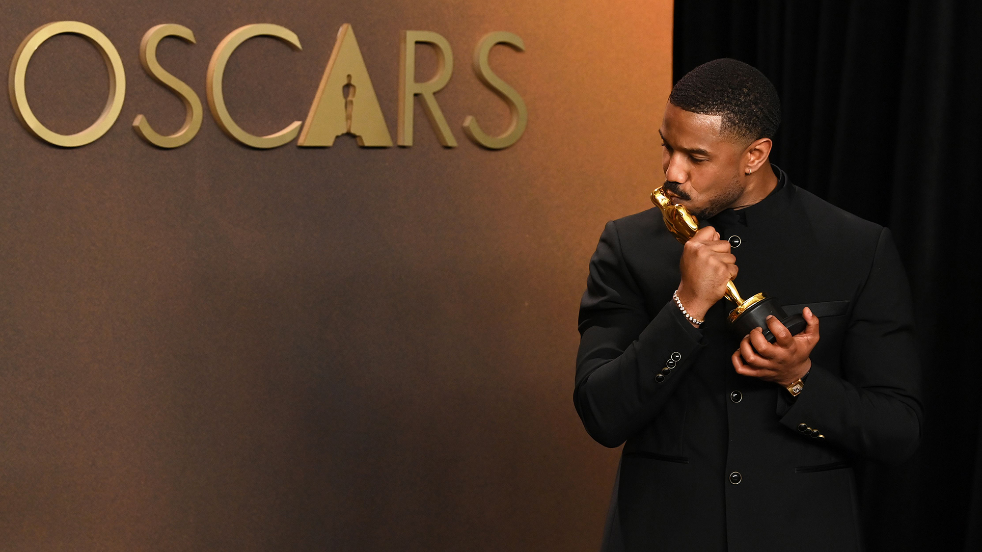 Michael B. Jordan kisses his award for Best Performance by an Actor in a Leading Role at the 98th Annual Academy Awards in Los Angeles