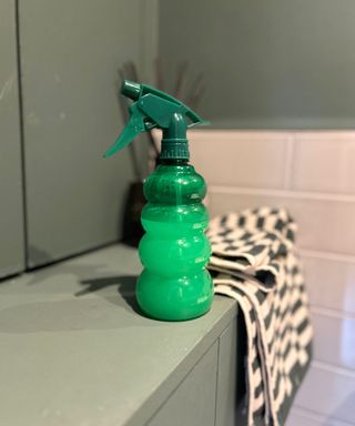 Green bottle sat on the side with Zoflora Disinfectant spray in it