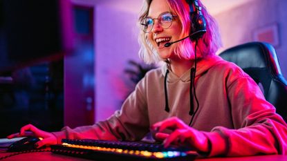 Woman playing games on a PC – wearing a gaming headset