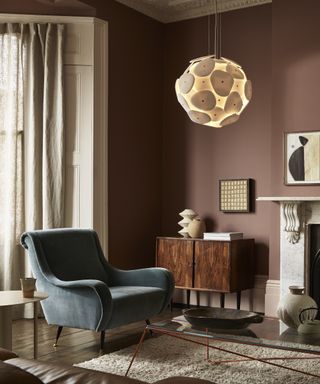 white pendant lighting in a brown living room with grey armchair