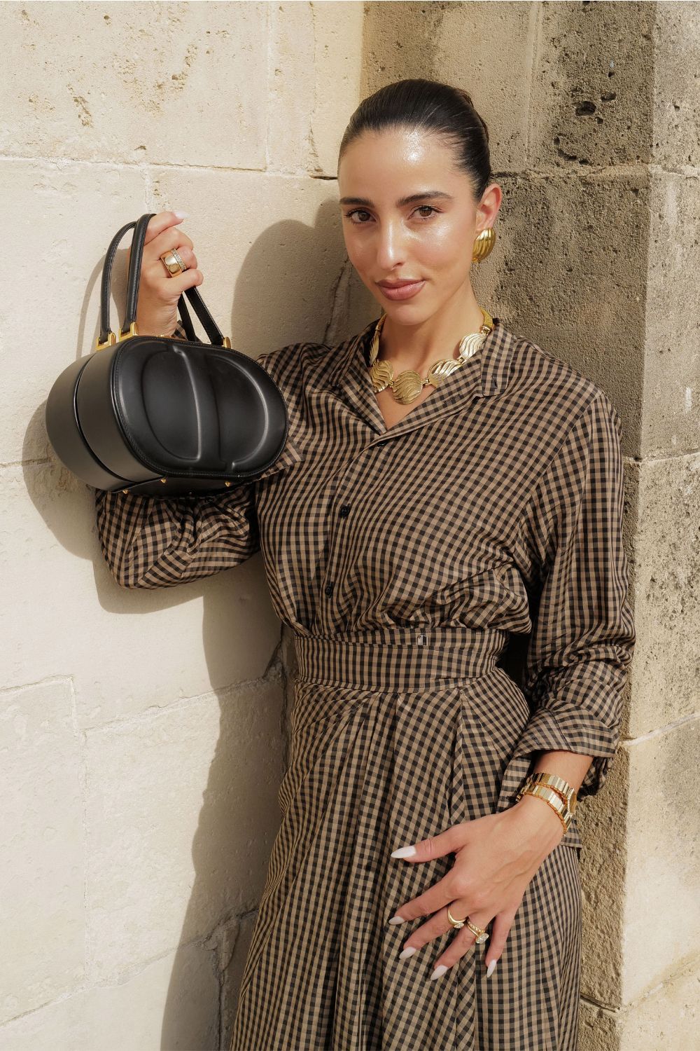 Bettina Looney at Dior Paris Fashion Week holding up her Dior handbag