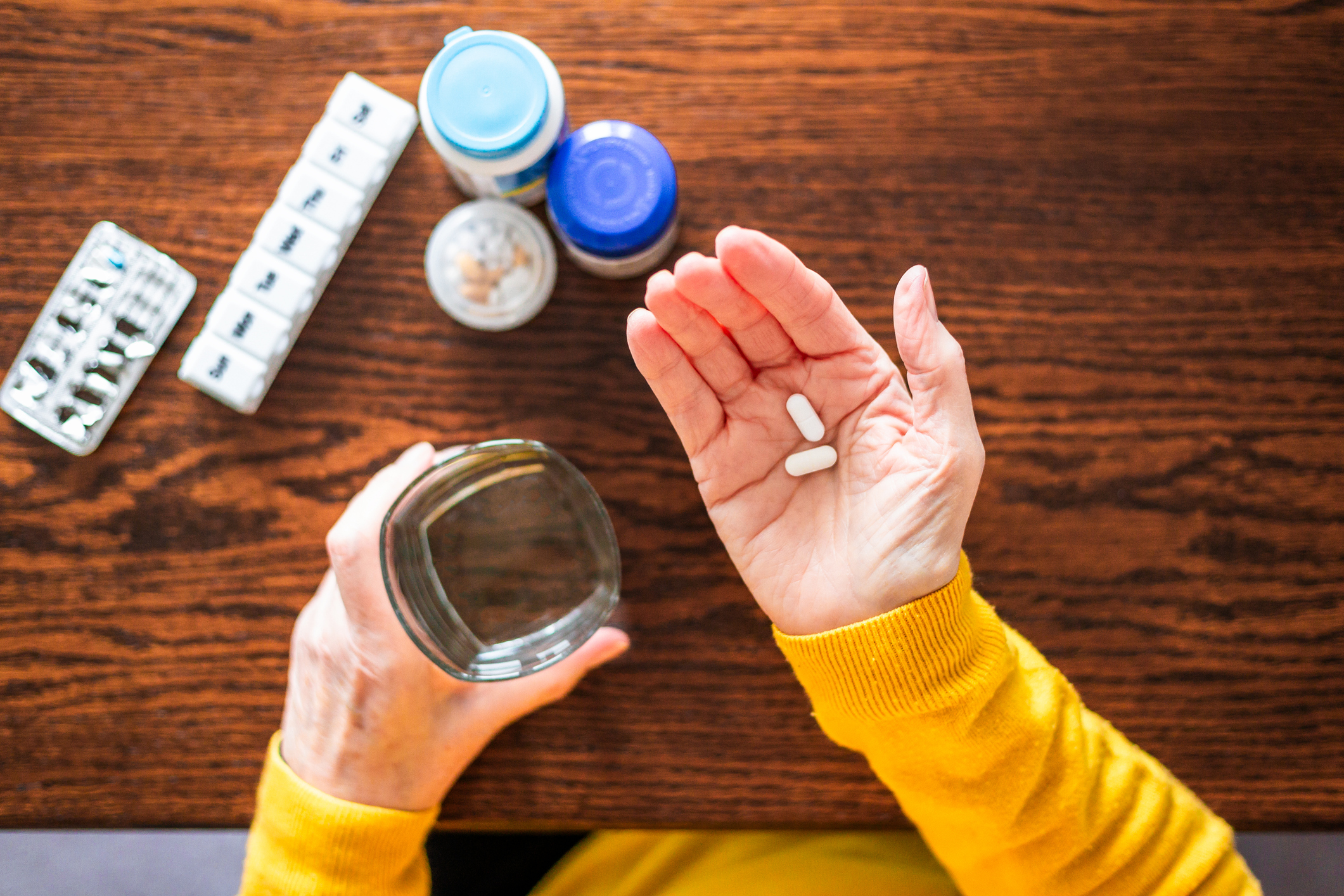 Overhead view of senior woman taking a medical pill