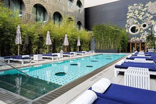sunken glass pool wrapped in the same pierced stainless steel sheeting that clads the hotel’s façade