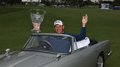Padraig Harrington poses for a photo with the winner's trophy in a miniature Aston Martin after the 2024 Hoag Classic Newport Beach