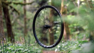 Easton's new EC90 ALX wheel floating in a forest