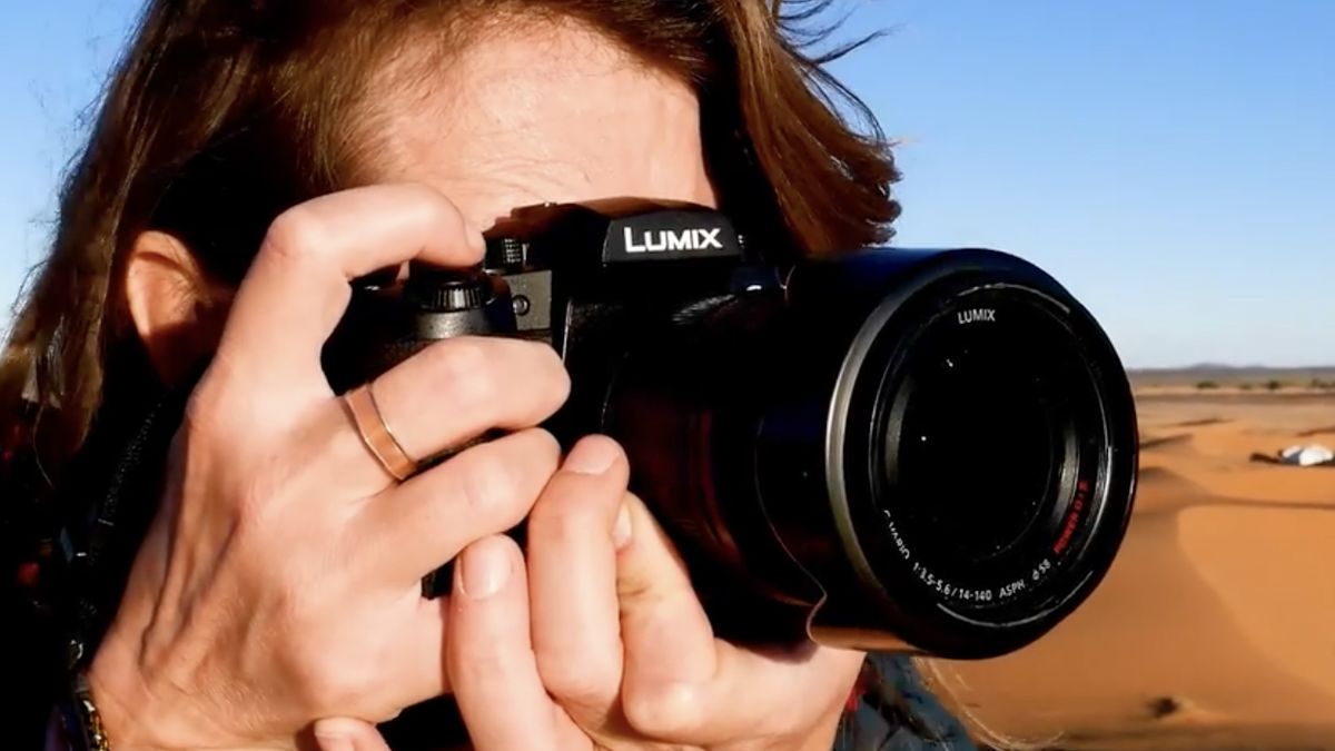 Panasonic Lumix G97 being held by a photographer in the desert