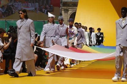 Louis Vuitton show with models holding flag