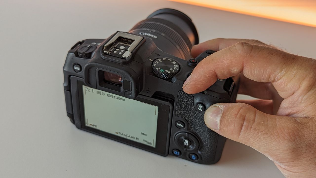 Canon EOS R8 set against a white backdrop with orange glow