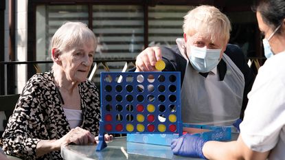 Boris Johnson playing Connect 4 with an old lady