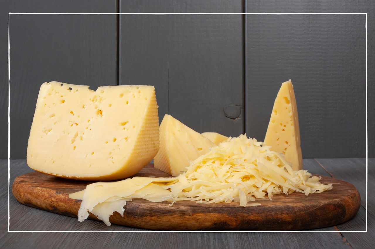 Various hard cheeses, including blocks and grated, on a wooden cheeseboard