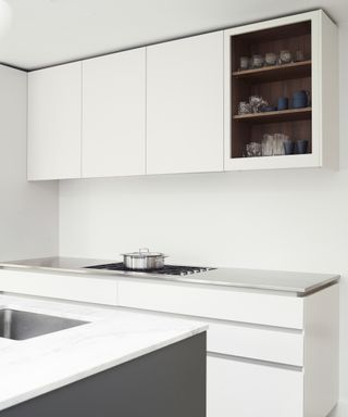 A modern kitchen with white handless cabinetry and a grey island