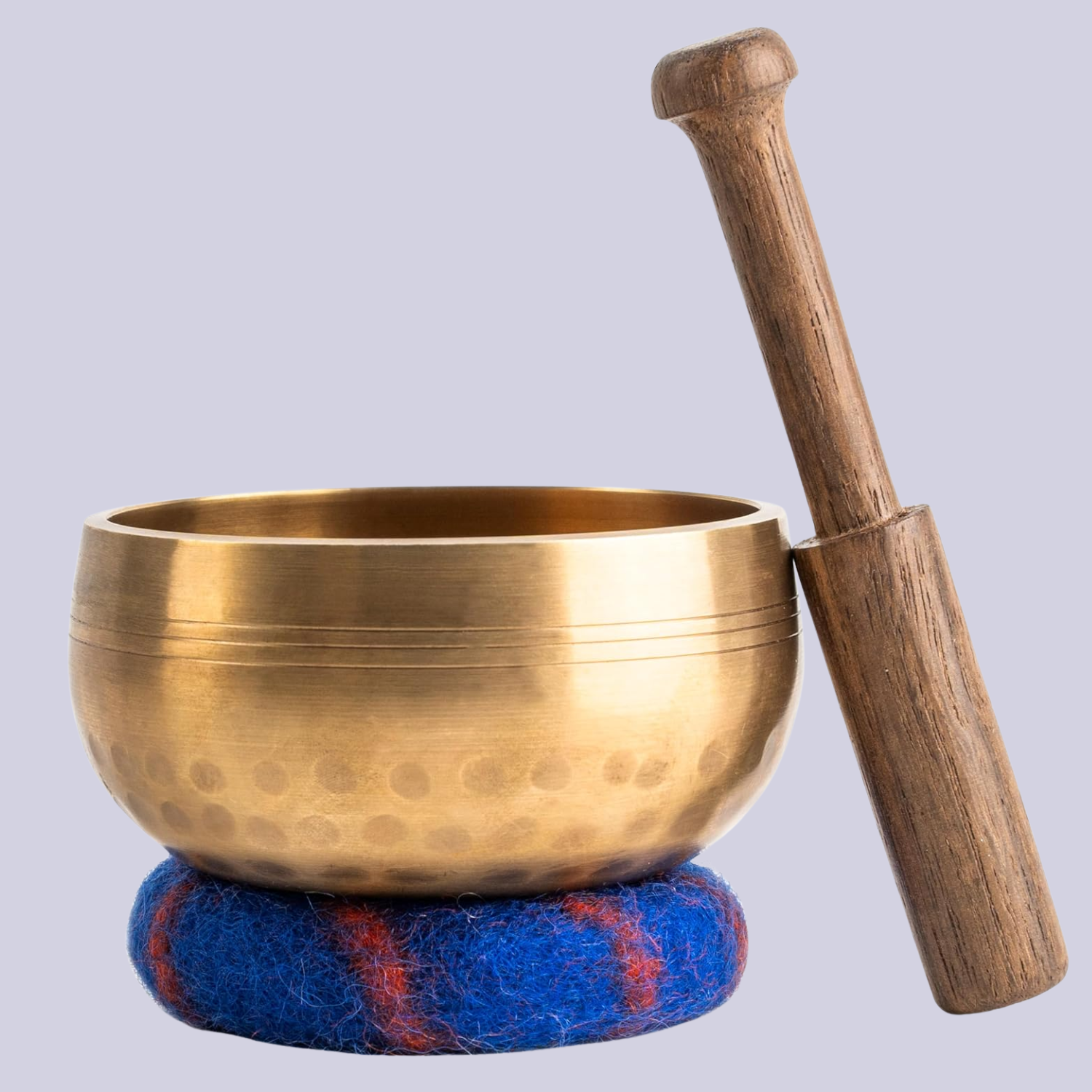 A Tibetan singing bowl with a wood accessory and a cobalt blue coaster