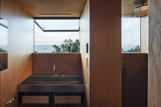 bathroom with window looking out to nature and blue skies in japanese tiny house
