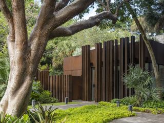 facade and exterior among plants of The Coconut Grove Gatehouse by Rene Gonzalez