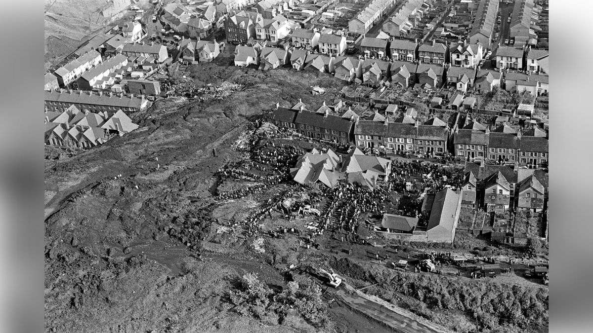 Aerial shot of houses and a school in town engulfed by a huge mound of coal spoil.
