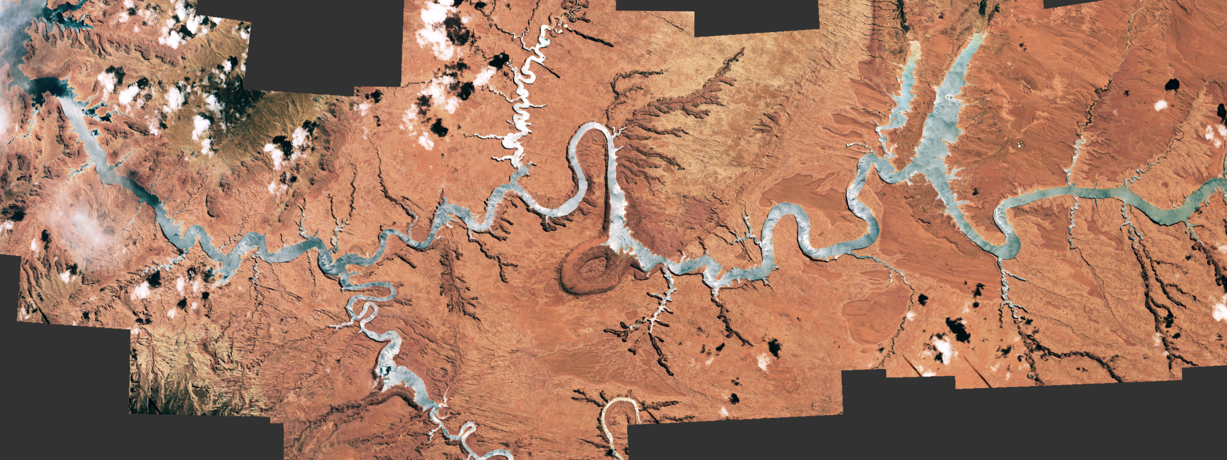 A mosaic of astroanut photos showing a giant river-like reservoir that has been turned silver by a sunglint 