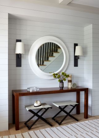 beachy hallway with mirror and wall lighting