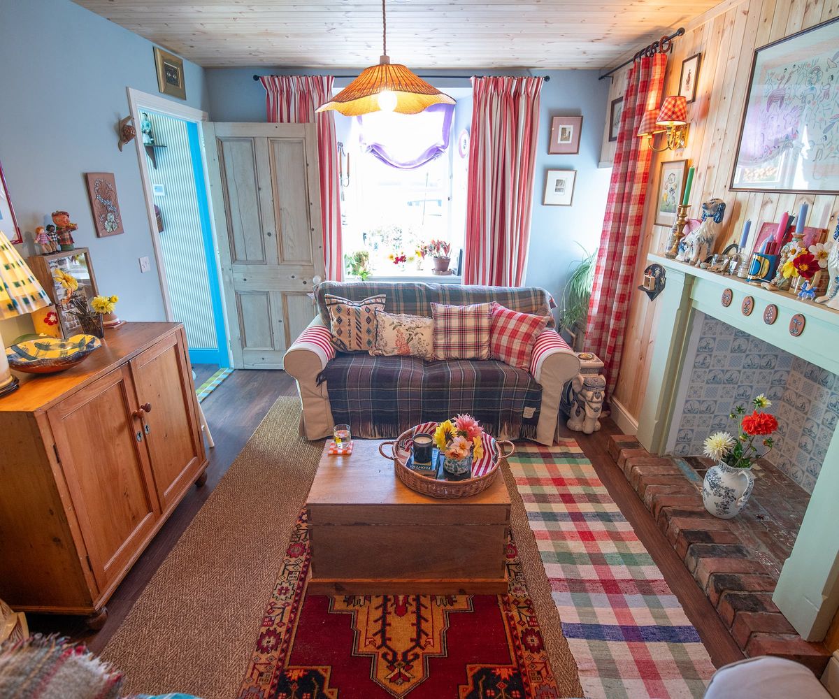 A living room with a tartan carpet and handmade wooden cabinet and coffee table