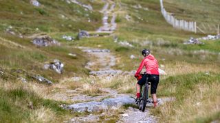 Female rider alone on part of An Turas Mor, a bikepacking route in Scotland