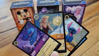 Disney Lorcana cards being held up