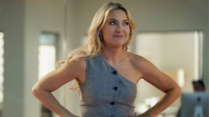 Kate Hudson looks to the side with her hands on her hips