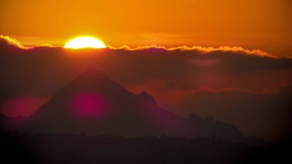 sun rising over mountain