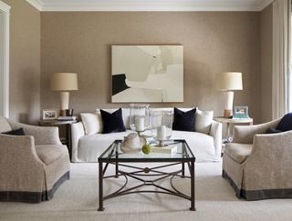 neutral living room with white sofa, neutral armchairs and glass coffee table