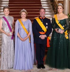Princess Elisabeth, Grand Duchess Stephanie, Grand Duke Guillaume, Princess Catharina-Amalia wearing evening gowns and military uniform in front of a staircase