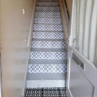 hallway with staircase cream wall and black white patterned flooring
