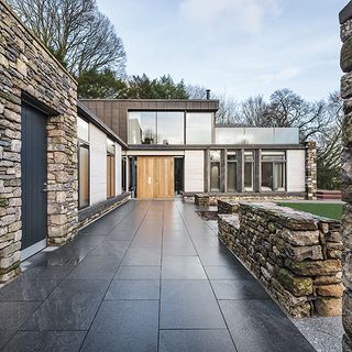 Exterior of house with stone wall and black flooring tiles