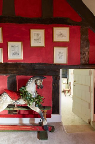 beamed landing painted dark red with antique rocking horse