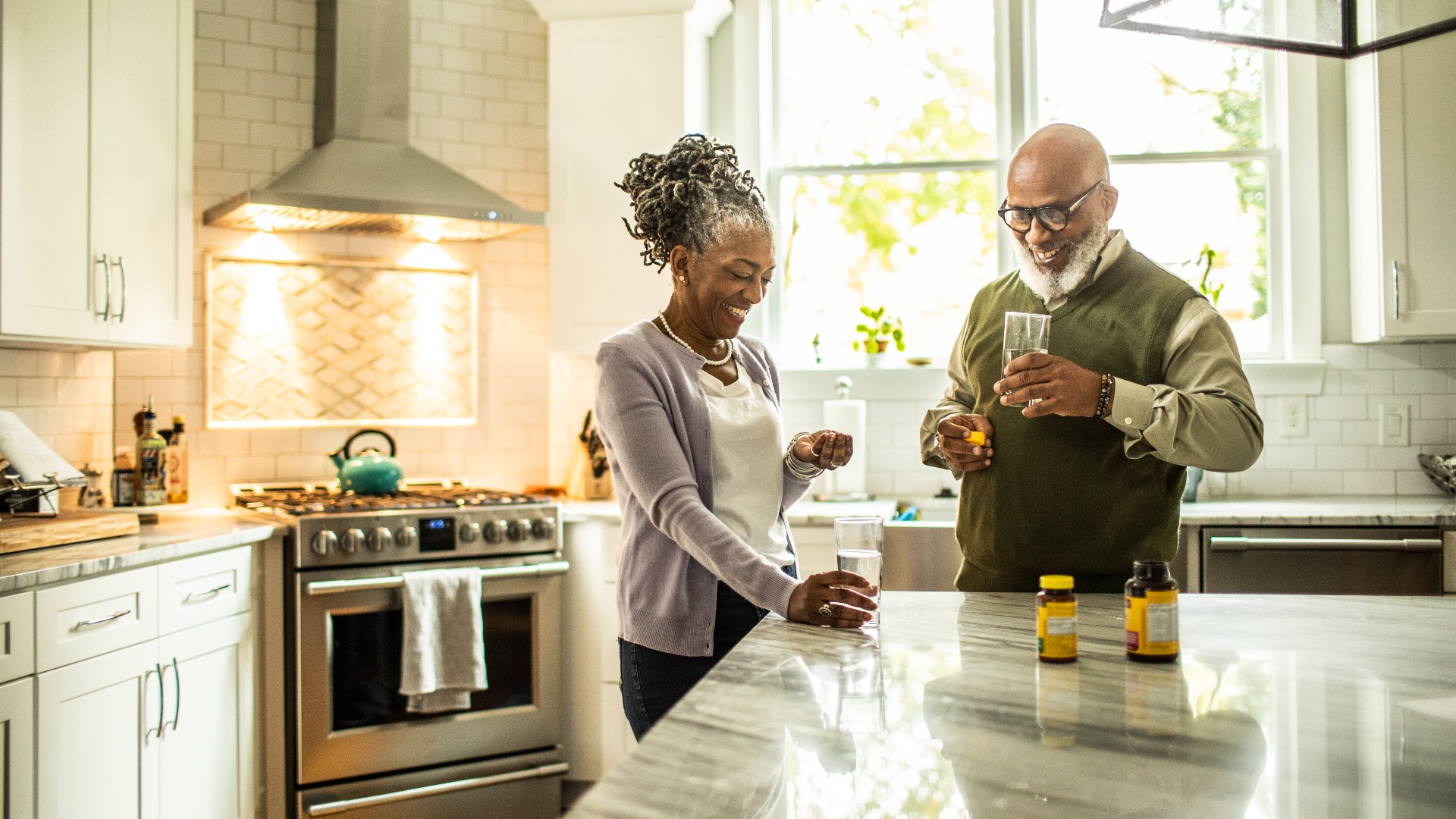 Elderly couple taking supplements in the kitchen