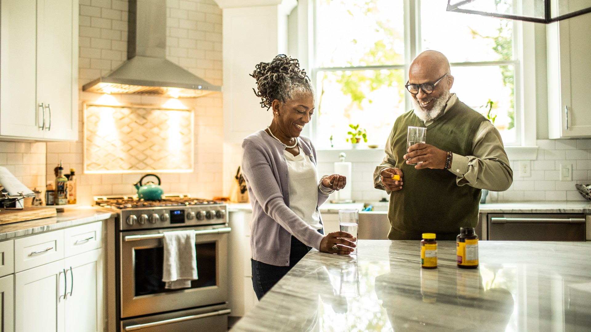 Senior pareja tomando suplementos en la cocina