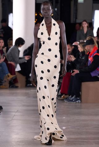 a photo of a model wearing a long polka dot halter dress on the Patou fall 2024 runway