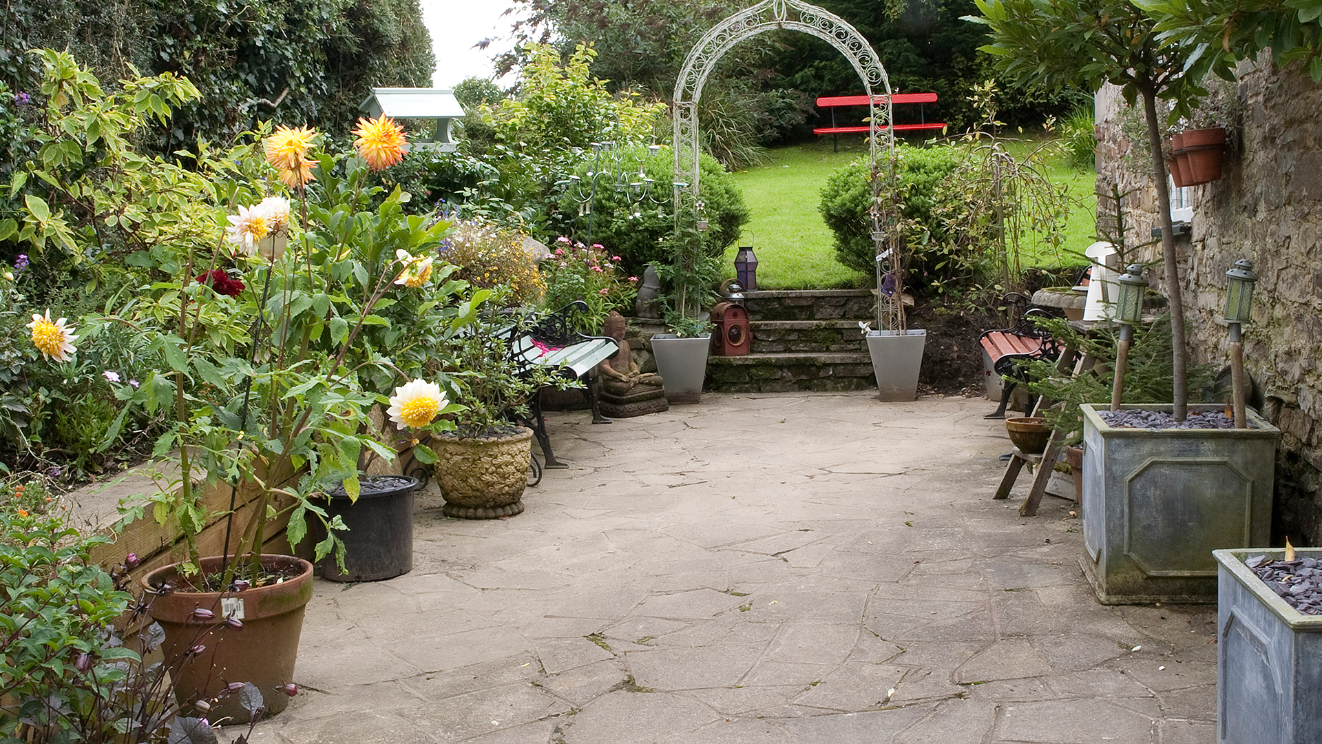 garden with patio area filled with potted plants