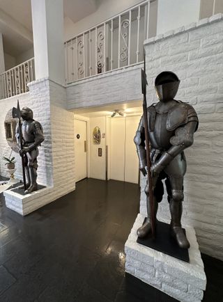 Two knights in armour flank the elevator entrance in the lobby of Parker Palm Springs