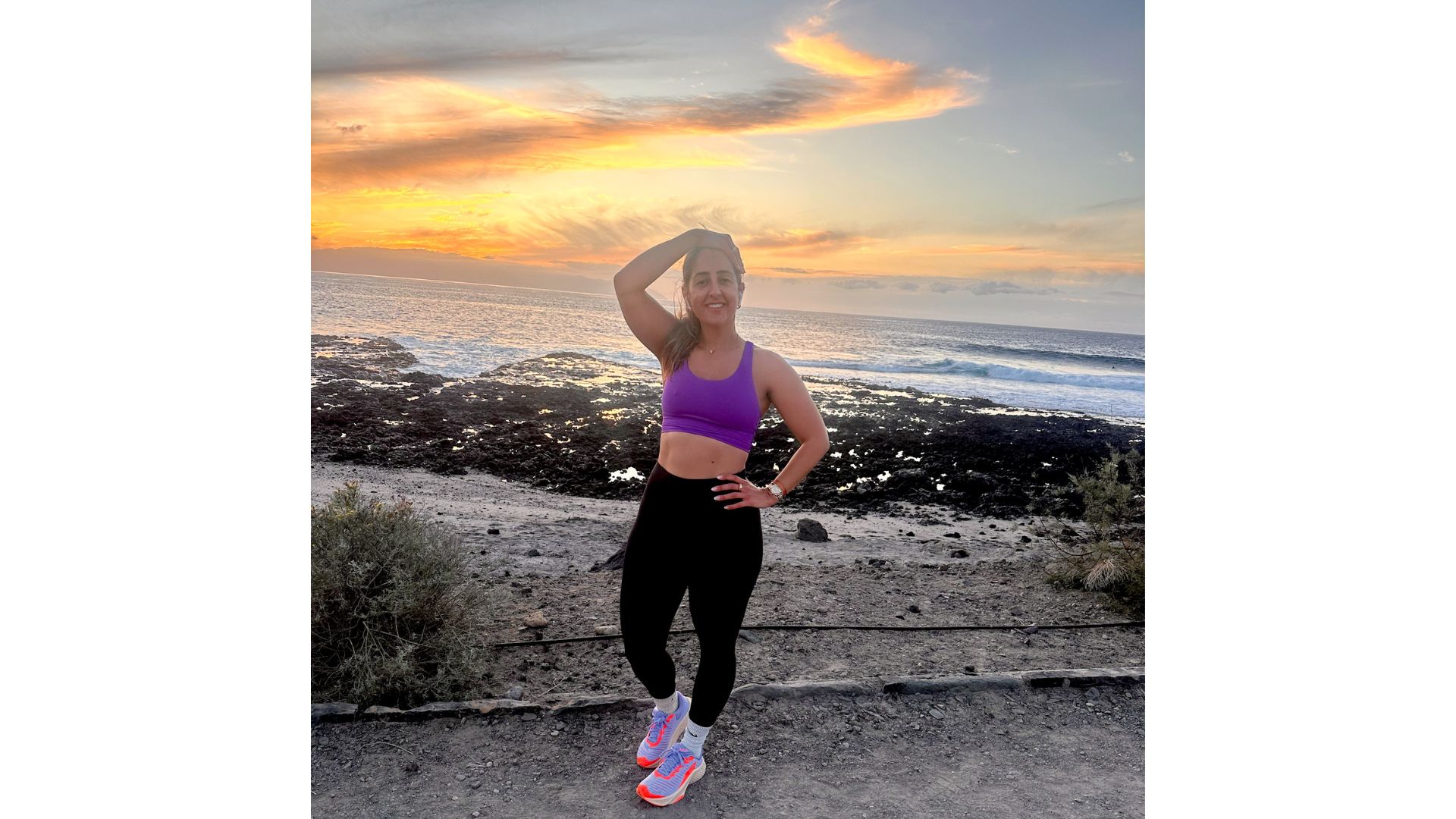 Sarah Shine in running clothes poses against a beautiful Tenerife sunset