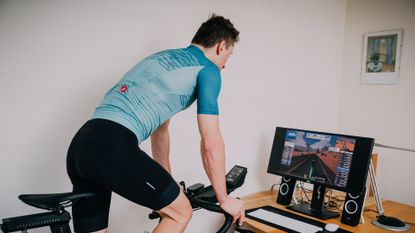 Image shows a cyclist riding on Zwift which is one of the best indoor training apps for cycling.