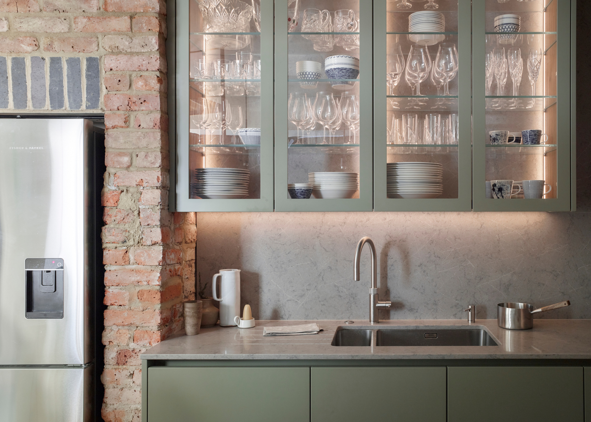 kitchen with green sage cabinets and glass fronted cabinets above