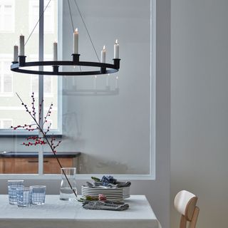 dining table with candle chandelier and plates with glasses