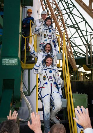 Expedition 31 Soyuz Commander Gennady Padalka (bottom), NASA flight engineer Joe Acaba and flight engineer Sergei Revin (top) wave farewell from the base of their Soyuz rocket at the Baikonur Cosmodrome in Kazakhstan shortly before launching toward the space station on May 14, 2012 (May 15 local time).