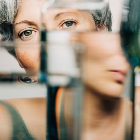 Portrait of female through glass of water. - stock photo