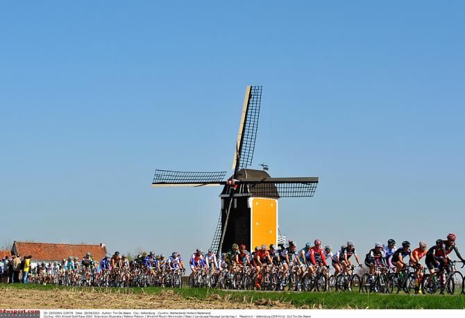 The peloton races past a windmill symbolic of Holland's Amstel Gold